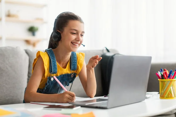 Онлайн-освіта. Дівчина використовує ноутбук, розмовляє під час відеозапису — стокове фото