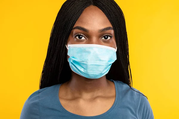 Milenial Lady negro con máscara facial sobre fondo de estudio amarillo —  Fotos de Stock