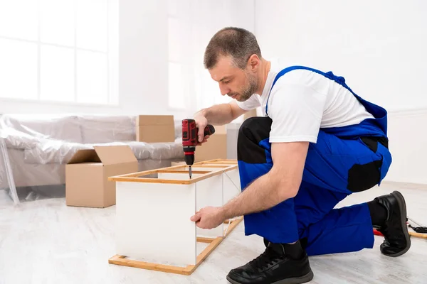 Heimwerker mit elektrischem Bohrer für Möbelmontage in Innenräumen — Stockfoto