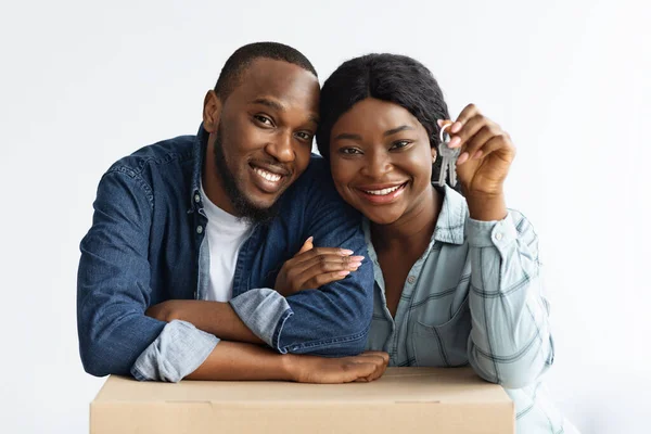 Vrolijk zwart getrouwd paar Holding Home Keys en leunend op kartonnen doos — Stockfoto