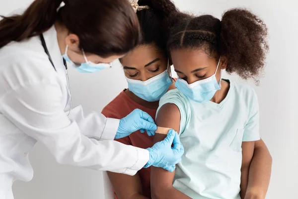 Familia afroamericana haciendo vacunación en el hospital, usando mascarillas — Foto de Stock