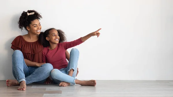 Glada afrikanska amerikanska mor och dotter sitter på golvet — Stockfoto
