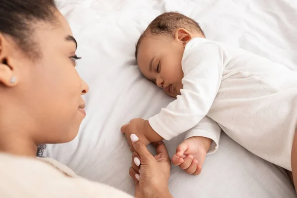 Ovanför-utsikt över sovande afroamerikanska baby och mor i sängen — Stockfoto