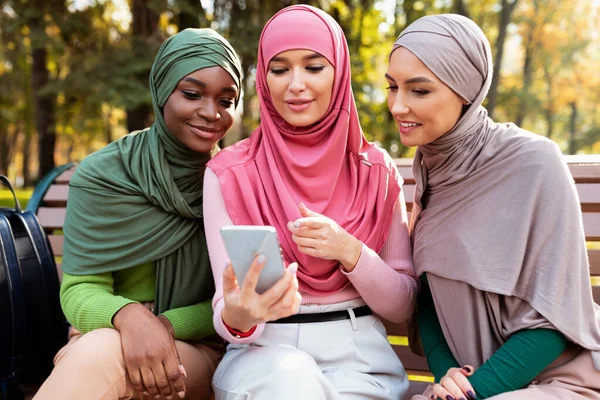 Grupo de estudiantes musulmanes mujeres usando el teléfono móvil aprendizaje al aire libre —  Fotos de Stock
