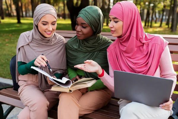 Grupp av moderna muslimska studenter damer som lär sig läsa böcker utanför — Stockfoto