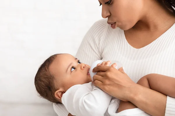 African American Mom Feeding Baby Giving Bottle With Milk Indoors — Stock Photo, Image