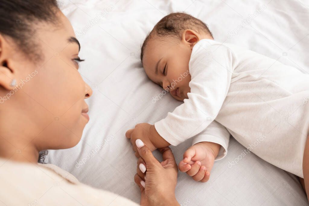 Above-View Of Sleeping African American Baby And Mother In Bed