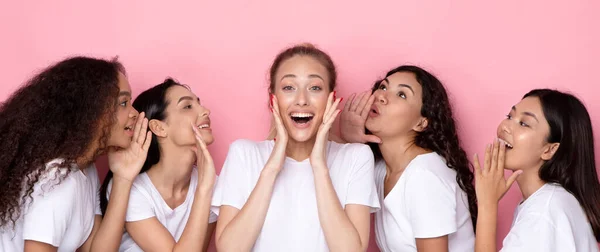 Cinco amigas multiraciales compartiendo noticias emocionantes sobre fondo rosa — Foto de Stock