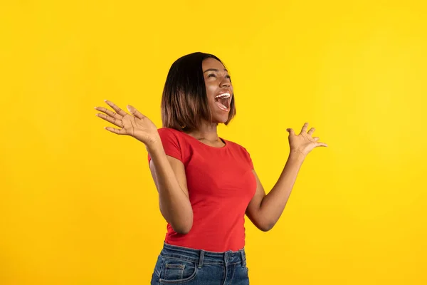 Senhora afro-americana emocional gritando em emoção sobre fundo amarelo — Fotografia de Stock