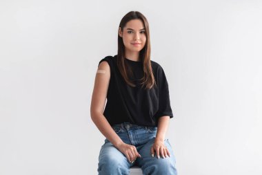 Kapsamlı aşı. Koronavirüs aşısı sonrası kolunda alçı olan genç bir bayan.