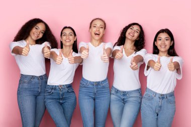 İki eliyle jest yapan çok ırklı kadınlar, pembe arka plan.