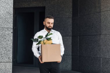İşsiz erkek işçi kişisel eşyalarla dolu bir kutuyla ofisten taşınıyor, işini kaybediyor ve parasız kalıyor, kopyalama alanı