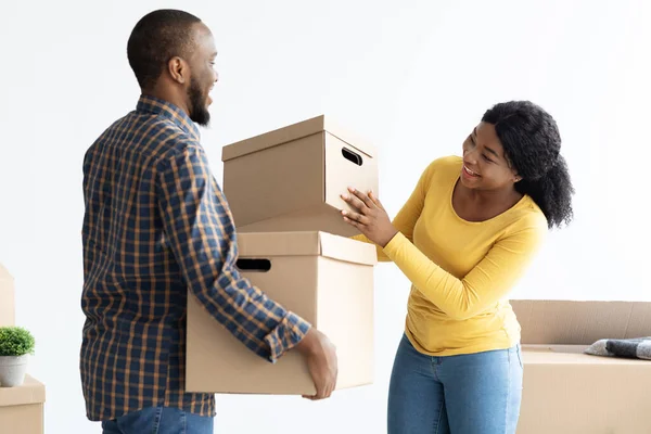 Verhuisdag. Portret van vrolijke jonge zwarte echtgenoten met kartonnen dozen — Stockfoto