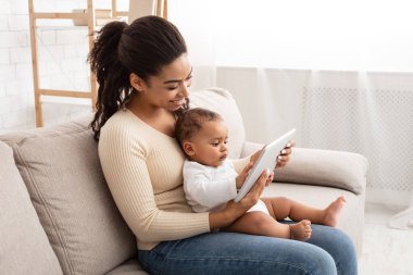 Mutlu Siyah Anne Tablet 'te Bebek Çizgifilmlerini İçerde Gösteriyor