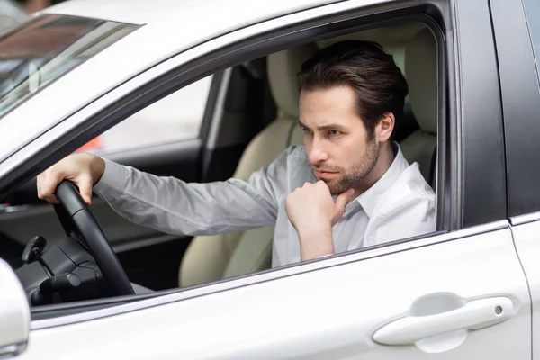 Genervt müder junger Mann am Steuer eines Autos. Geschäftsmann kommt zu spät zum Treffen — Stockfoto