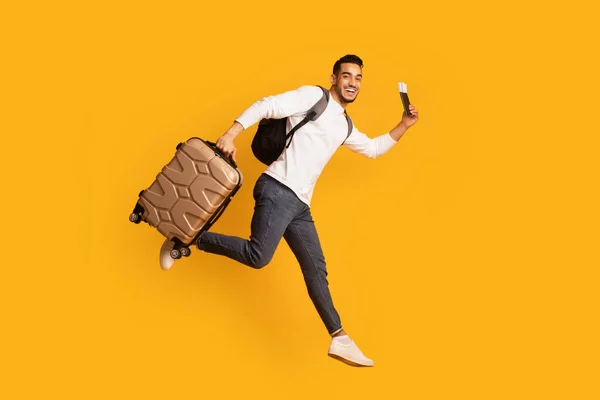 Çanta ve pasaportla atlayan genç mutlu bir Arap 'ın portresi. — Stok fotoğraf