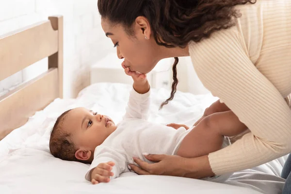 African Mommy Kissing Babys Hand Waking Up After Sleep Indoor — Stock Photo, Image