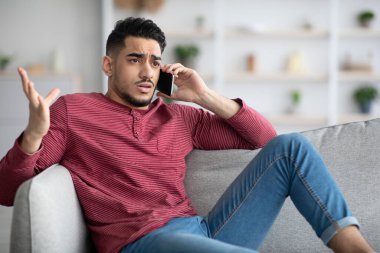 Sinirli Arap adam telefonda konuşuyor.