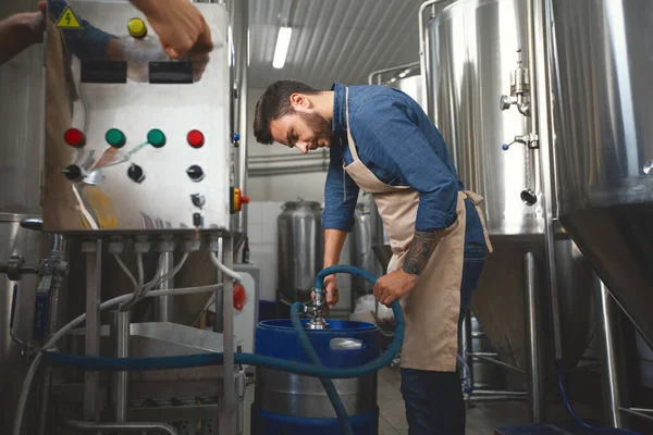 Apparatuur in moderne fabriek, brouwerij, werknemer werk met ambachtelijk bier — Stockfoto