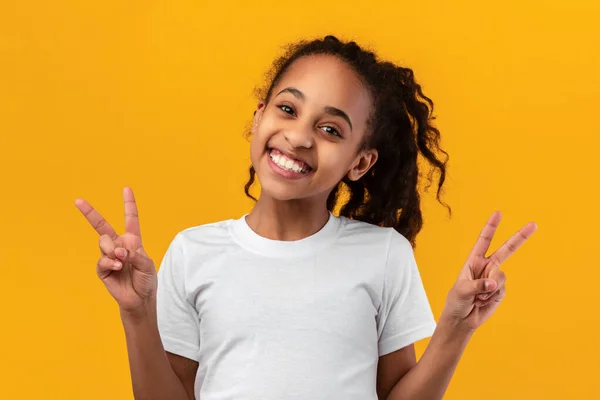 Портрет усміхненої чорної дівчини-підлітка, що показує знак миру — стокове фото