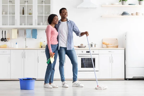 Belo casal americano africano limpeza cozinha, olhando para o espaço de cópia — Fotografia de Stock