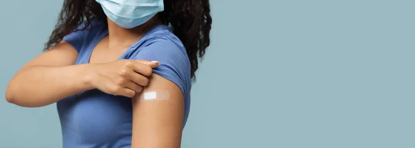 Antivirale vaccinatie. Afrikaans-Amerikaanse vrouw toont gips op schouder na covid-19 vaccin injectie, panorama — Stockfoto