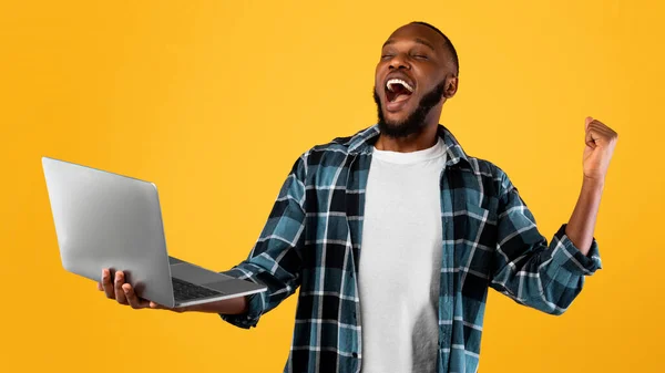 Aufgeregter Schwarzer mit Laptop und schreiender Gestik Ja, Studio — Stockfoto