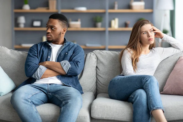 Crisis Relacional. Ofendida pareja interracial sentada en un sofá después de la pelea —  Fotos de Stock