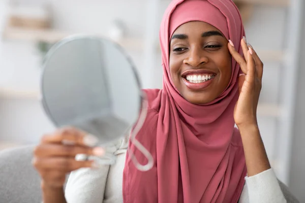 Il concetto di bellezza. attraente nero islamico signora in hijab cercando in ingrandimento specchio — Foto Stock