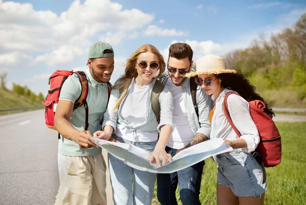 Yol boyunca harita kontrolü yapan, otostop çeken sırt çantalı en iyi arkadaşlar grubu.