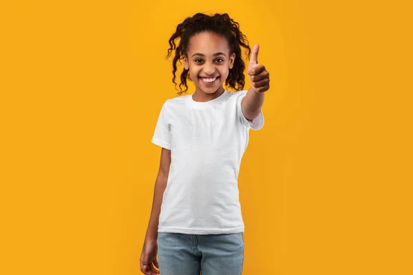 Glückliches schwarzes Mädchen gestikuliert mit erhobenem Daumen und lächelt — Stockfoto