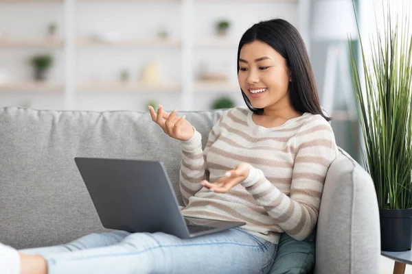 Szczęśliwy młody uśmiechnięty Azji lady co wideo rozmowy na laptop w domu — Zdjęcie stockowe
