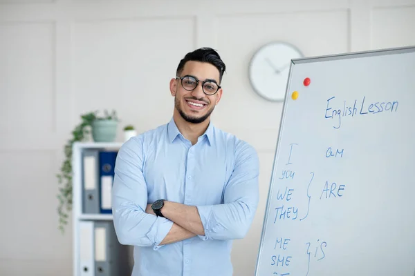 거리 학습. 온라인 영어 수업을 하고 있는 행복 한 아랍 남자 교사, 칠판 앞에서 팔짱을 끼고 서 있는 모습 — 스톡 사진