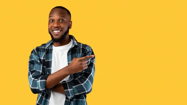 African Guy Pointing Finger Aside Showing Blank Space, Yellow Background — Stock Photo, Image