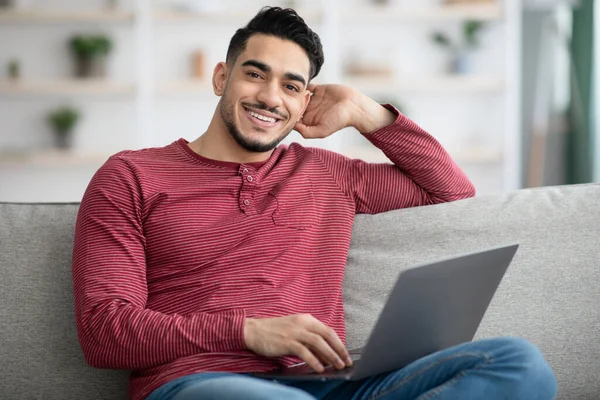 Nahaufnahme eines glücklichen arabischen Mannes, der seinen neuen Laptop genießt — Stockfoto