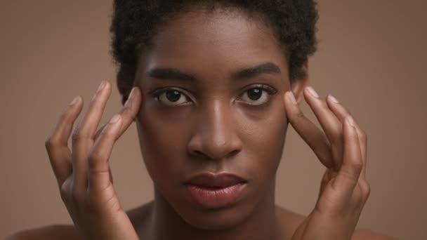 Closeup Retrato de mulheres afro-americanas massagem templos, fundo bege — Vídeo de Stock