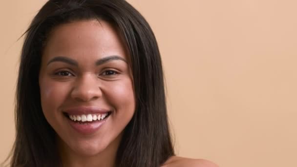 Zwarte vrouw poseren glimlachen en steken uit tong, Beige achtergrond — Stockvideo