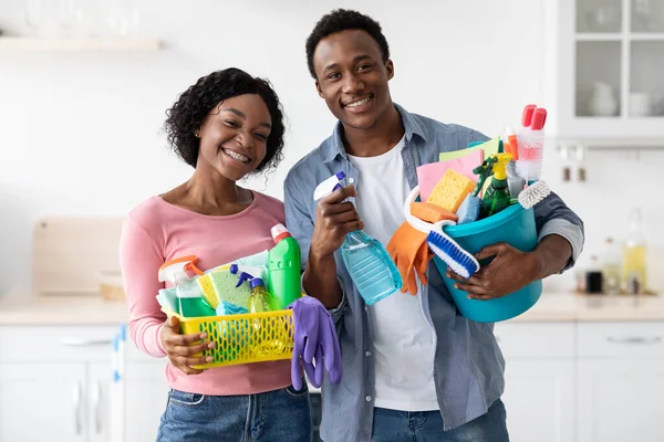 Pasangan kulit hitam positif dengan alat pembersih berpose di dapur — Stok Foto