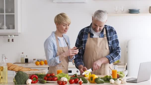 Esposa Fotografiando En Smartphone Mientras Marido Cocinar En Cocina Moderna — Vídeos de Stock