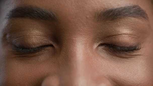 Zwarte vrouw met bruine ogen op zoek naar camera, close-up portret — Stockvideo