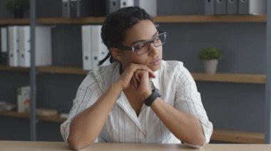 Sıkıcı Afrikalı Amerikalı kadın ofis çalışanı üzgün hissediyor, yan bakıyor ve üzgün bir şekilde nefes alıyor.