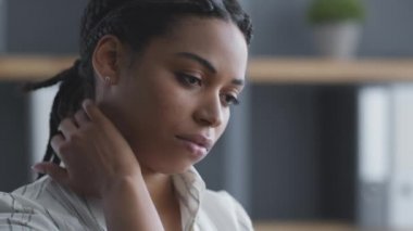 Ofis sendromu konsepti. Yorgun Afrikalı Amerikalı bayan ofis çalışanı boynuna masaj yapıyor, ağrıları var.