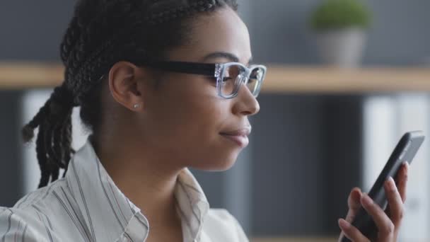 Смартфон Дружба афроамериканка - агент з продажу в окулярах, який розмовляє з клієнтом через смартфон. — стокове відео
