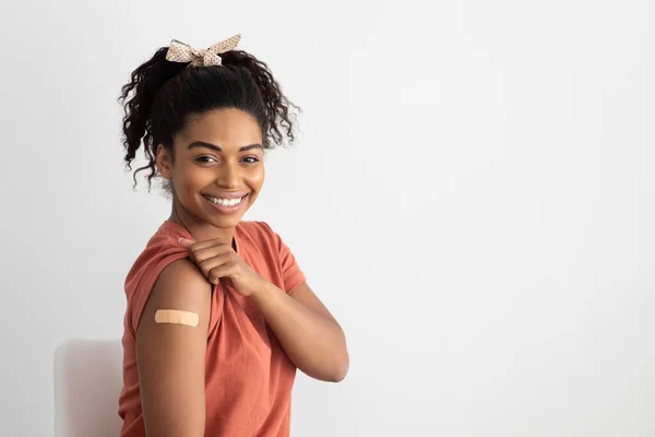 Гарненька чорна жінка, що показує медичну групу на плечі — стокове фото