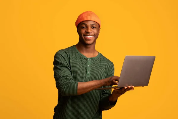 젊고 행복 한 아프리카 계 미국인 남자가 랩탑 컴퓨터를 가지고 있는 모습 — 스톡 사진