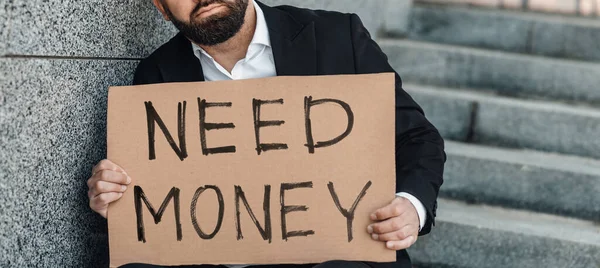 Felismerhetetlen érett üzletember kezében poszter karton szükség pénz szöveg, panoráma, termés — Stock Fotó