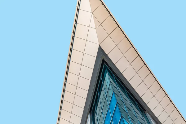 Nowoczesna architektura. Szklana elewacja budynku biurowego na tle błękitnego nieba, widok z niskiego kąta, uprawa, przestrzeń do kopiowania — Zdjęcie stockowe