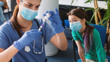 Şırıngalı bir doktor. Şırıngadan Kovan 19 aşısı alıyor.