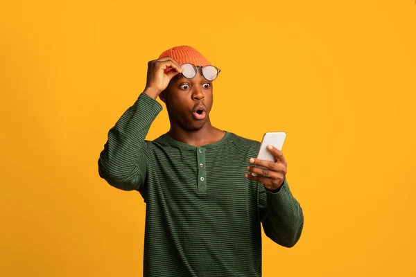 놀라운 앱이죠. 스마트 폰 화면을 보고 있는 충격을 받은 아프리카 계 미국인 — 스톡 사진