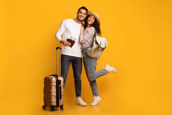 Allegra coppia mediorientale con valigia, passaporti e biglietti di viaggio, pronta per le vacanze — Foto Stock